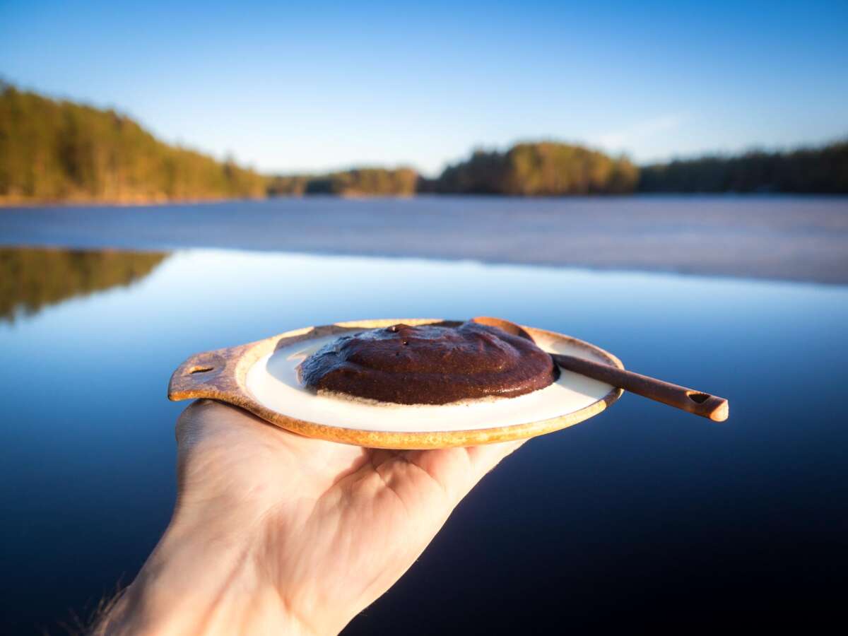 Nuuksio National Park in spring, in April. Enjoying Finnish Easter delicacy mämmi at a lake. Finnish nature near Helsinki, Finland.