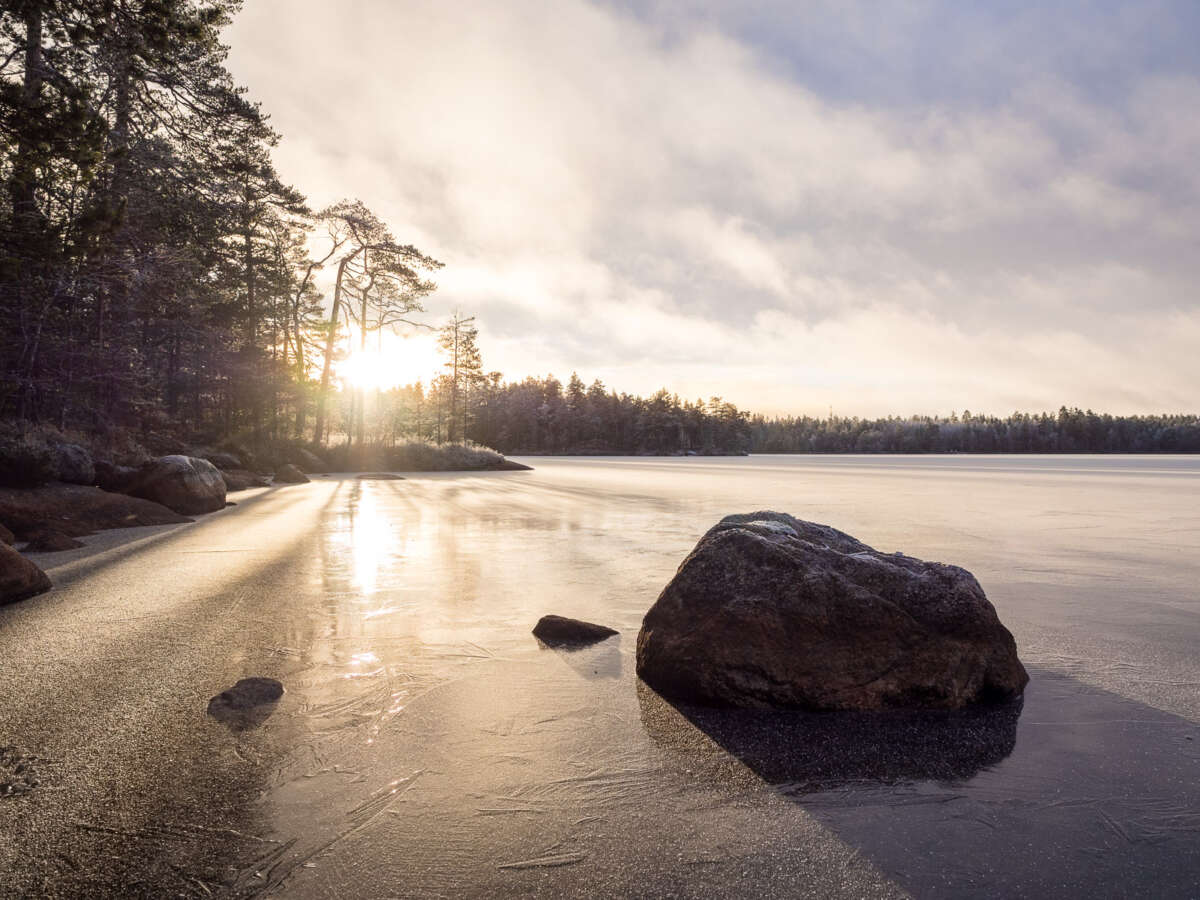 Nuuksio National Park in winter. Hiking at the frozen lakes, snow clouds coming in. Nature near Helsinki, Finland.