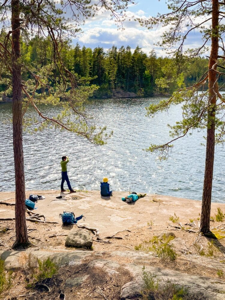Family relaxing by a lake in Nuuksio National Park