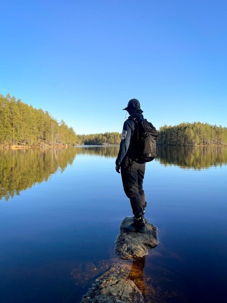 Hiker looking over a calm lake in Nuuksio National Park
