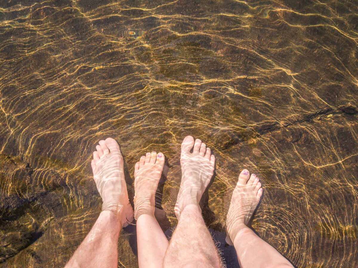 Nuuksio National Park in summer, in July. Standing in a crystal clear lake when the waters are warm.